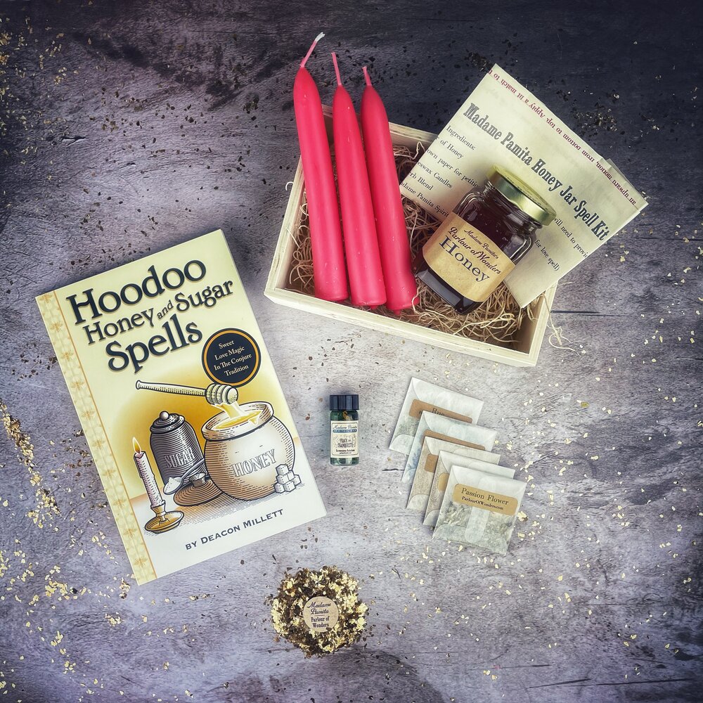 Hoodoo Honey and Sugar Spells kit with candles, honey, and book on a textured surface