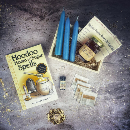 Hoodoo Honey and Sugar Spells book with blue candles and honey jar on a textured surface