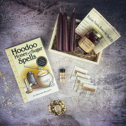 Hoodoo Honey and Sugar Spells kit with candles, honey, and book on a textured surface