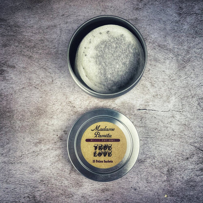 Tin of 'True Love' potpourri with a label on a textured surface