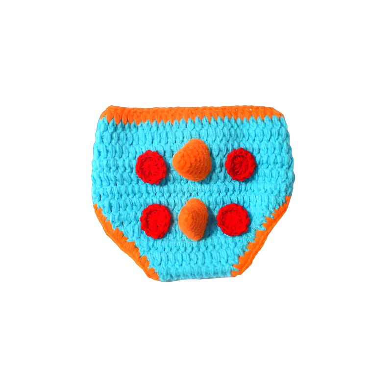 Crocheted dog toy with orange border and red pom-poms on a white background
