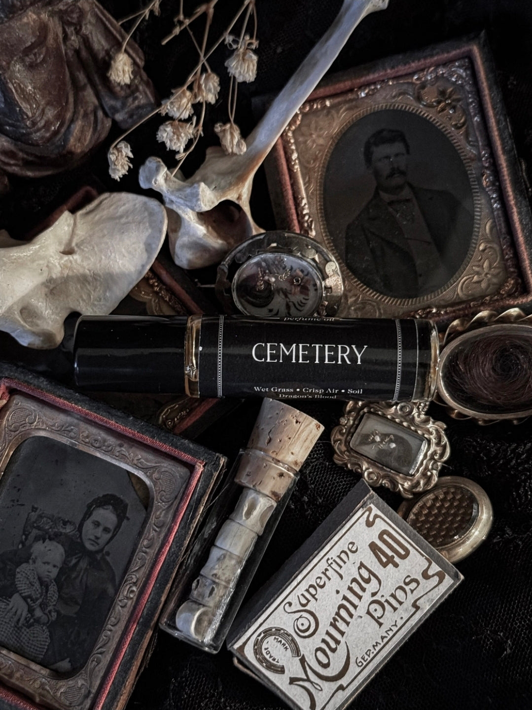 Vintage-style items including a skull, photo album, and 'Cemetery' book on a dark background.