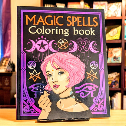 Coloring book titled 'Magic Spells' with a cover featuring a woman with pink hair and wiccan symbols.