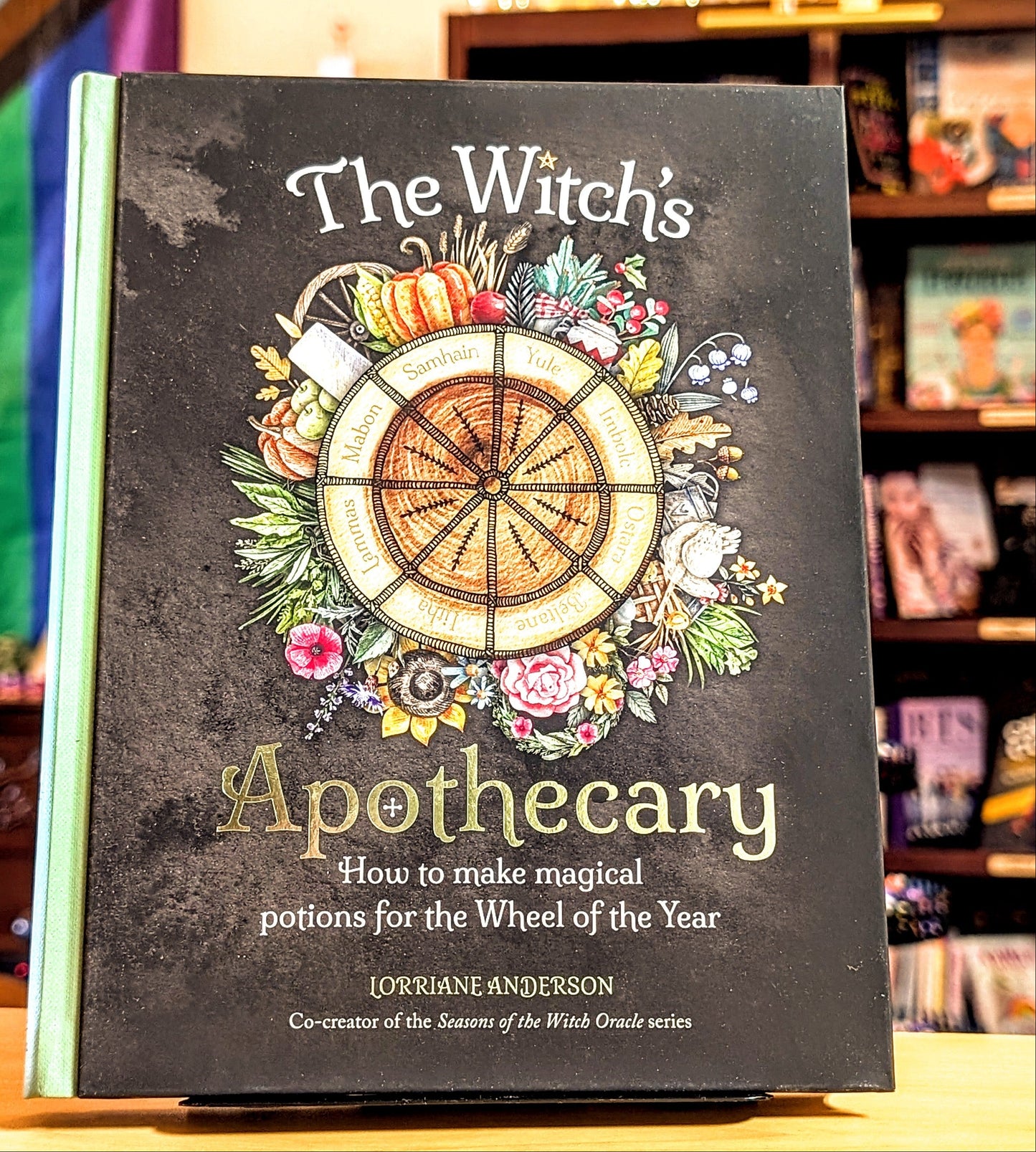 Book titled 'The Witch's Apothecary' on a shelf with colorful background