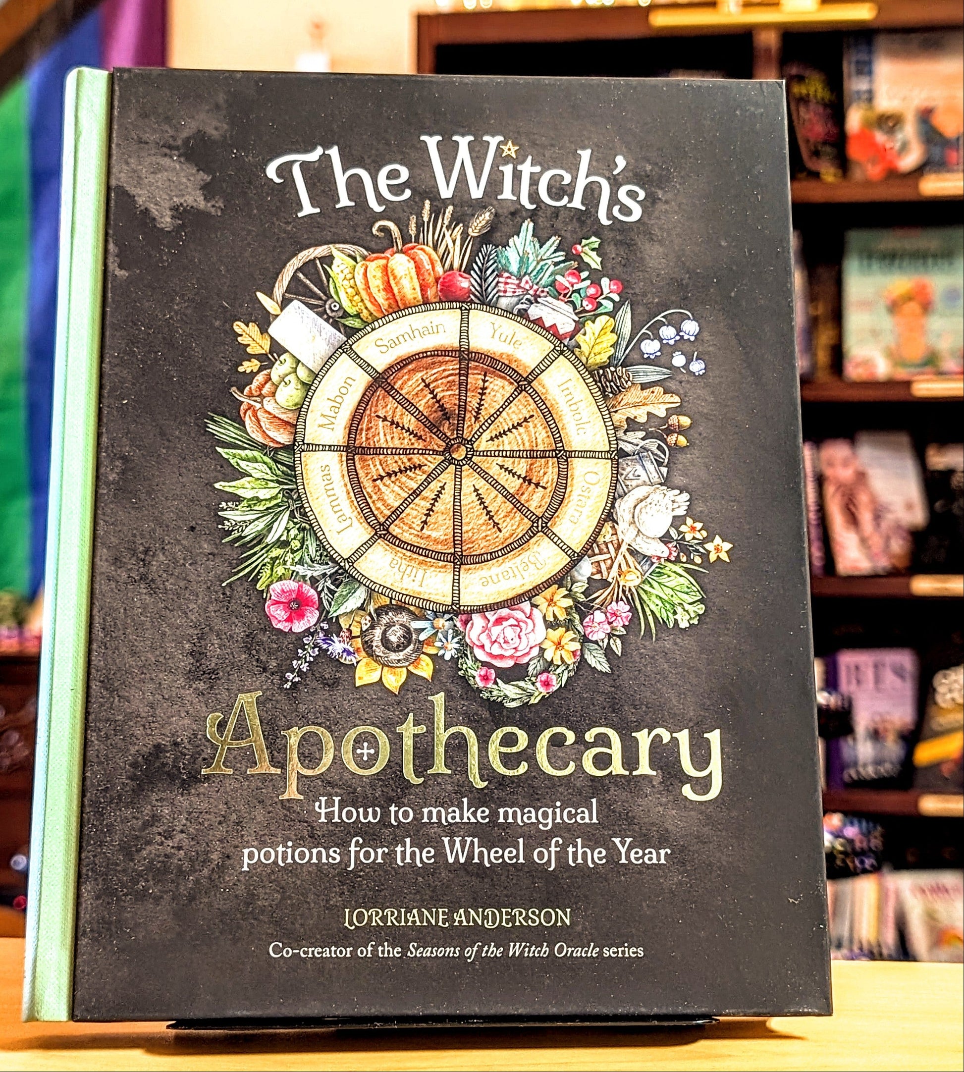 Book titled 'The Witch's Apothecary' on a shelf with colorful background