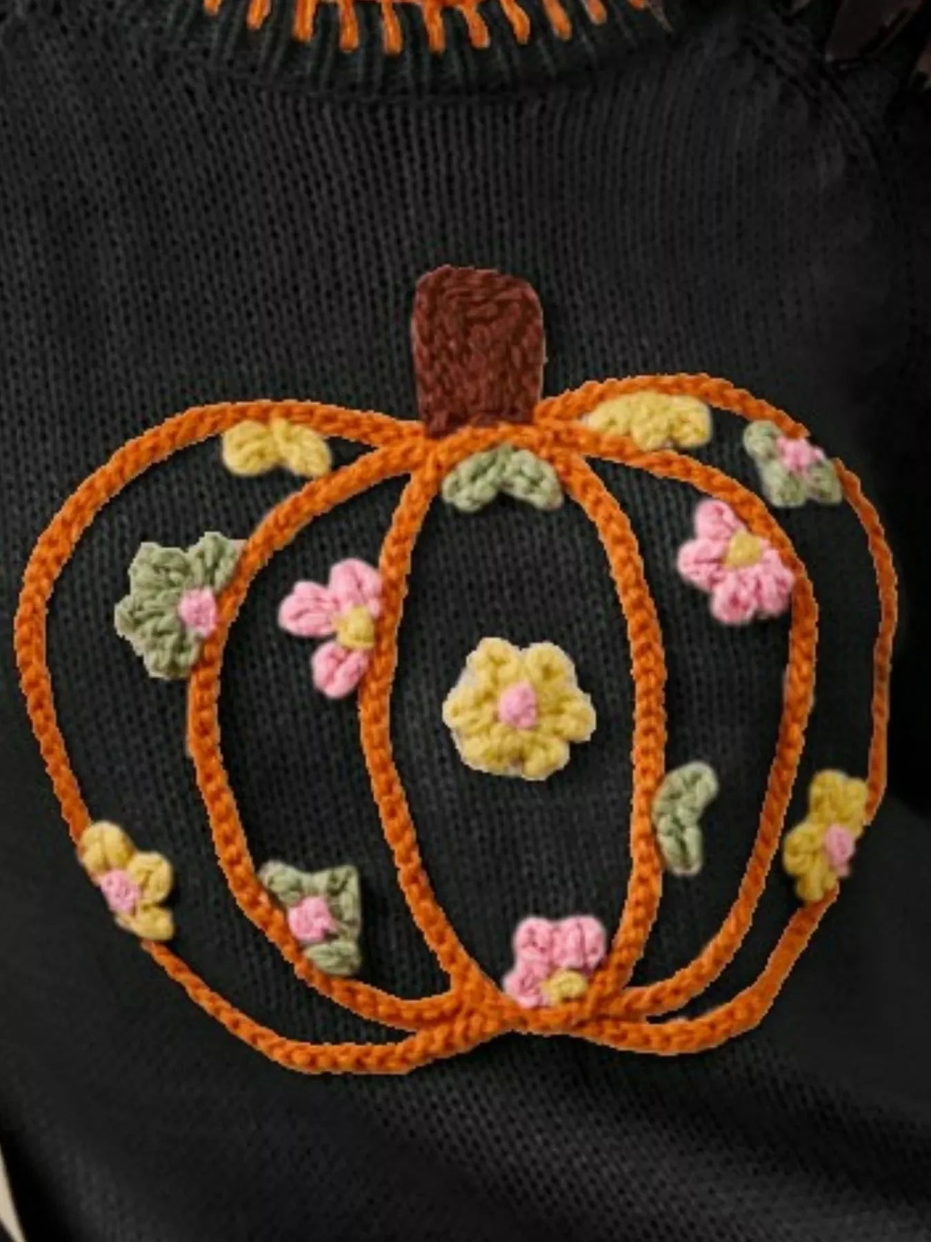 Embroidered pumpkin design on a black background with colorful flowers.