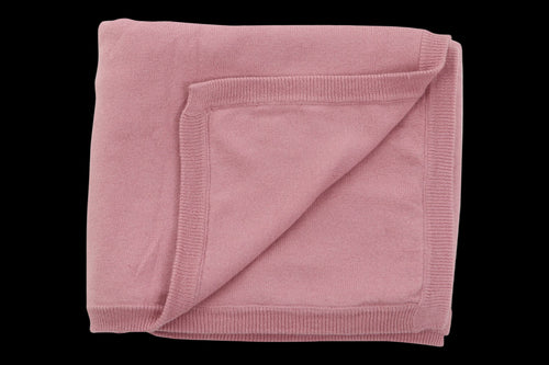 Folded pink blanket on a white background