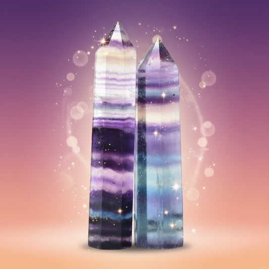 Two multicolored crystal towers on a white surface with a blurred background