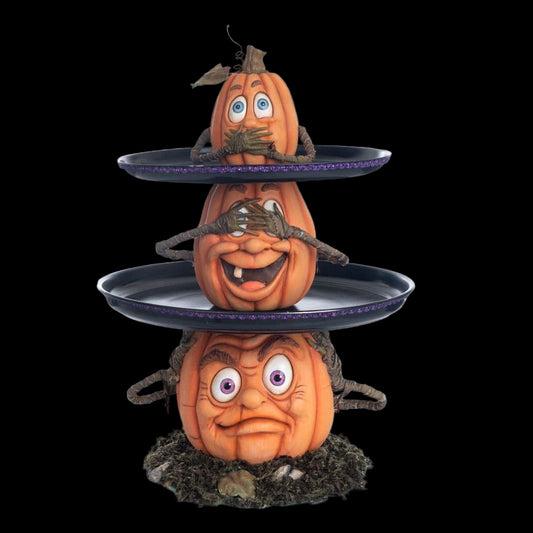 Three-tiered Halloween pumpkin display with carved faces and spider webs on a white background