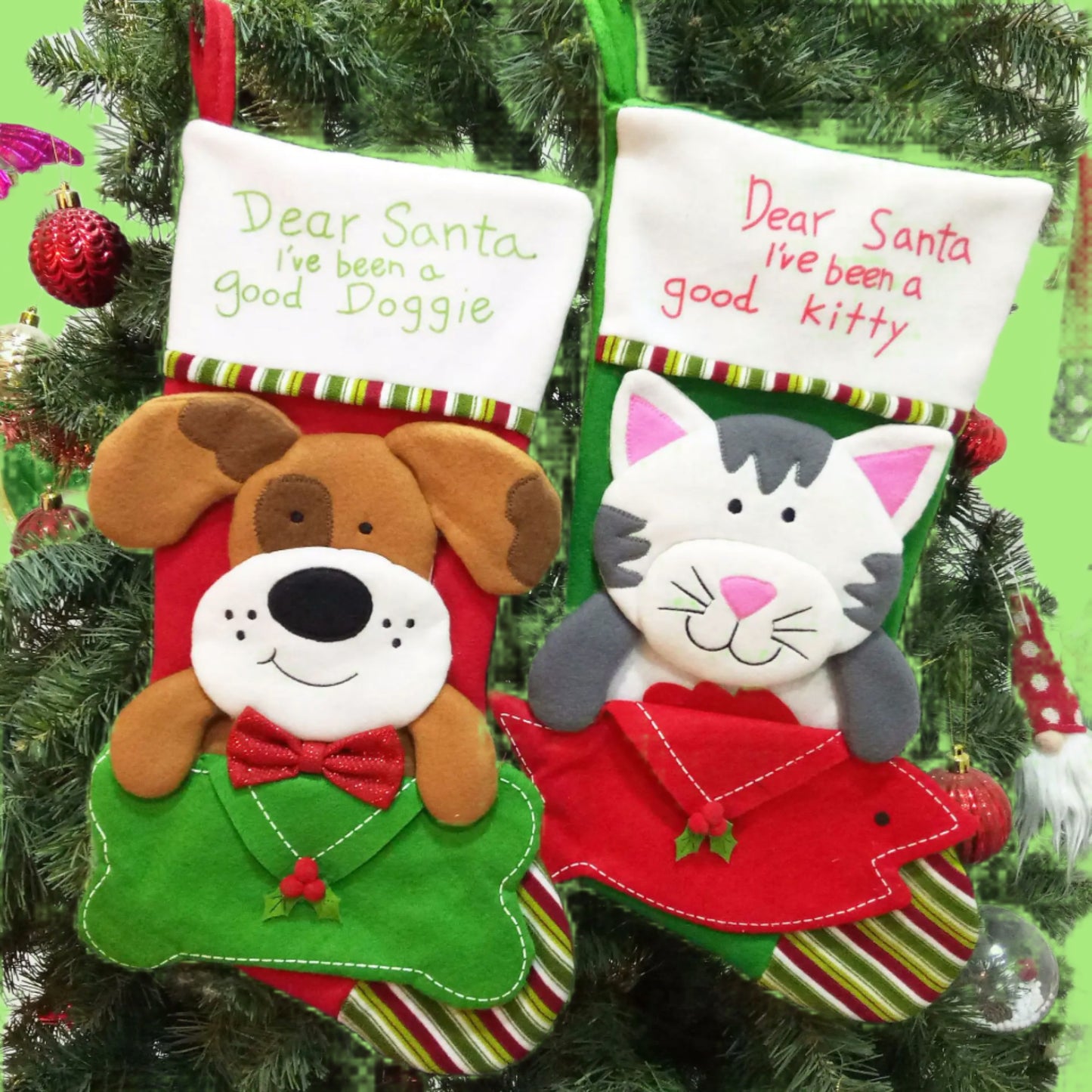Two Christmas stockings for pets, one with a dog design and the other with a cat design, hanging on a tree.