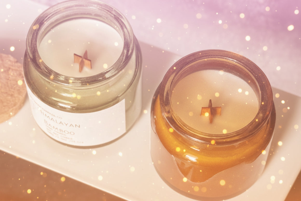 Two candles in glass jars on a white surface