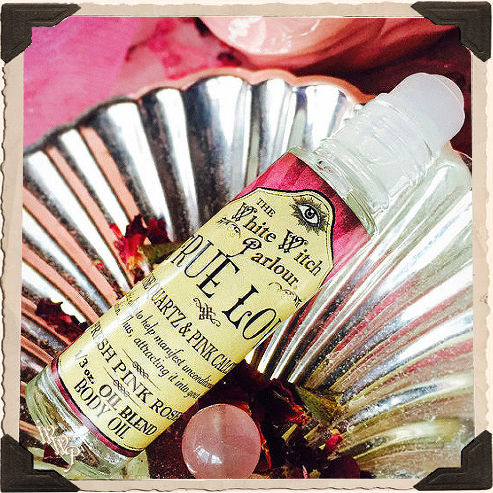 Small bottle of body oil with a decorative label on a pink and silver background