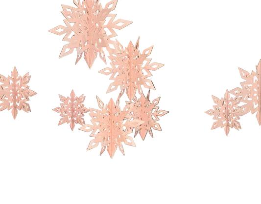 Decorative pink snowflakes hanging in a room with a stone fireplace and table.