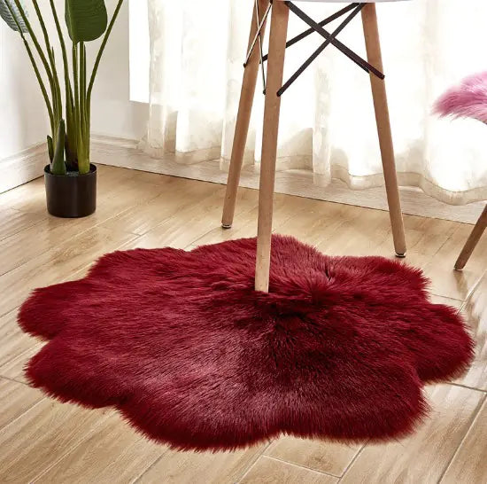 Red faux fur rug on a wooden floor with a plant and chair in the background