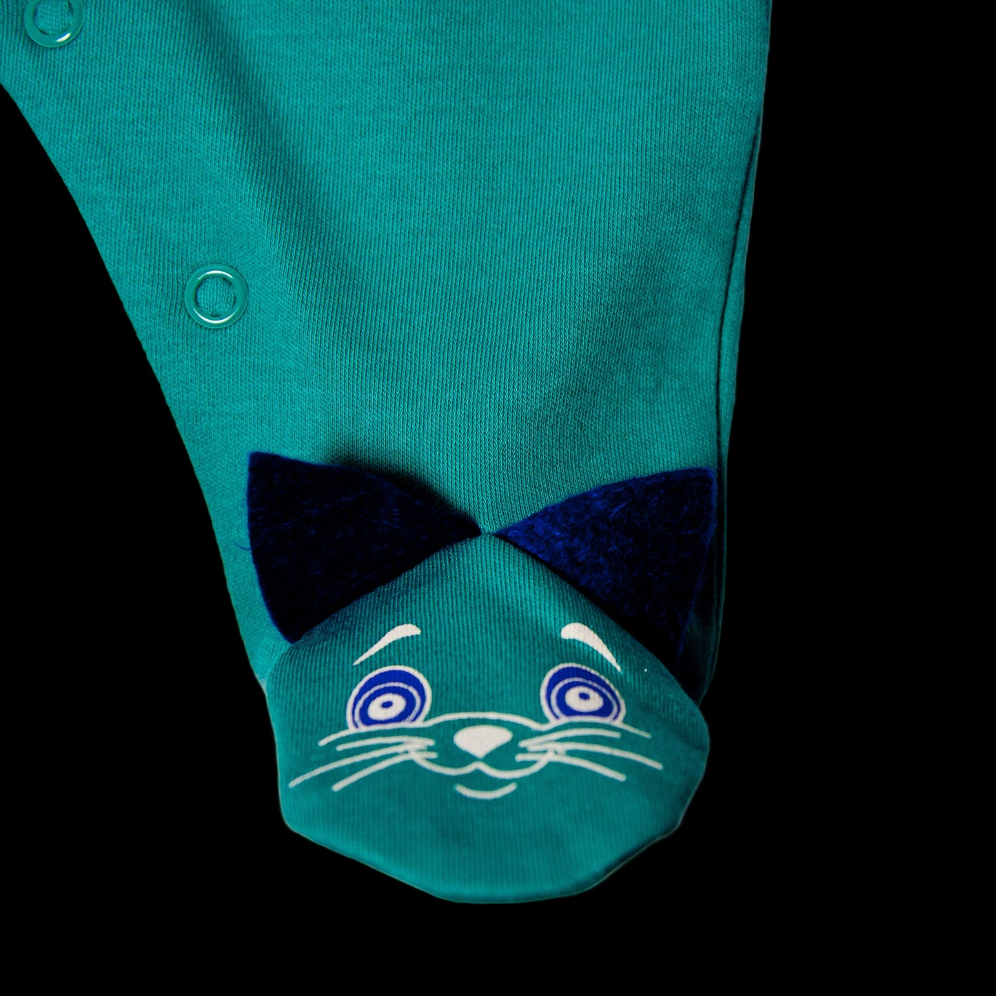 Green baby romper with cat face design on a white background