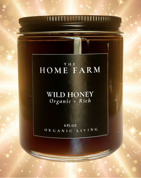 Candle jar labeled 'The Home Farm Wild Honey' on a white background