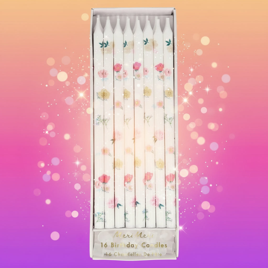 Set of floral birthday candles in a decorative box on a white background