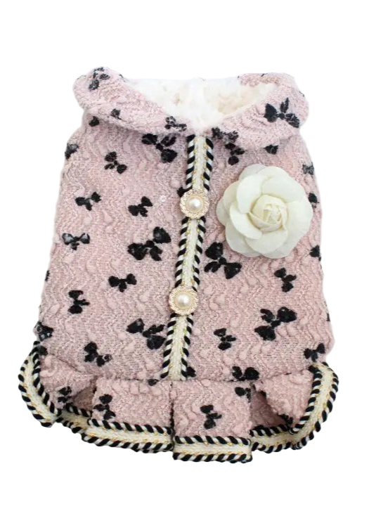 Pink dog coat with black bow pattern on a white background
