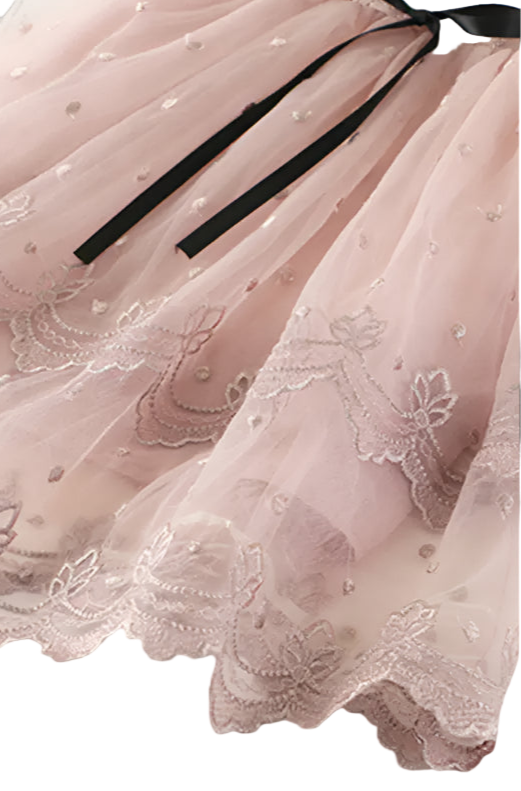 Close-up of a pink lace dress with a black ribbon on a white background