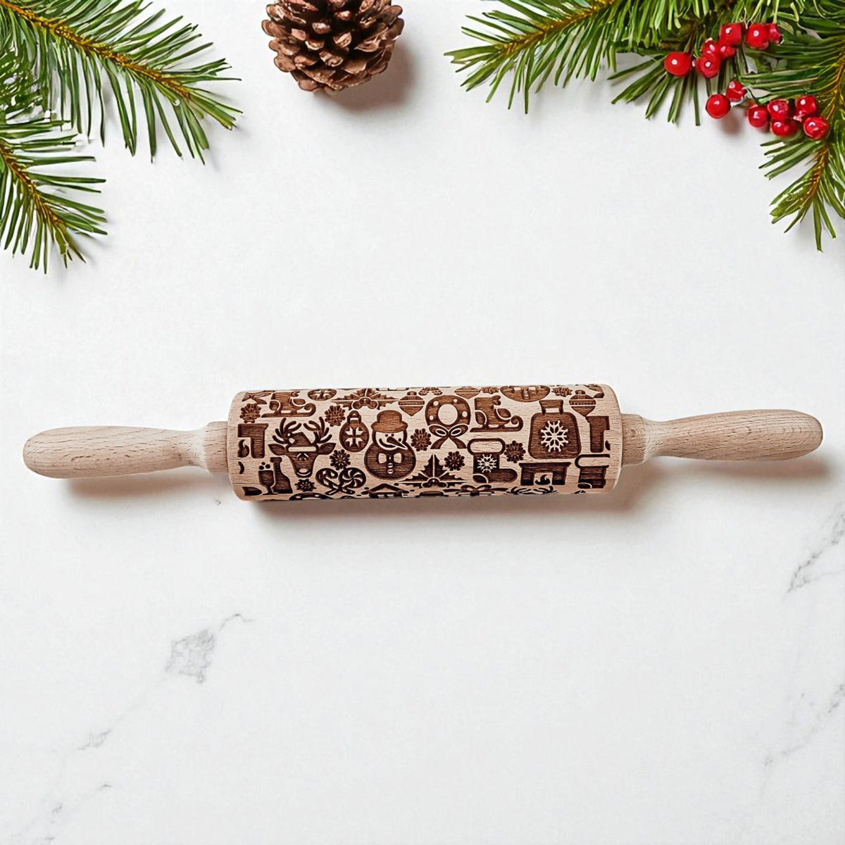 Wooden rolling pin with Christmas designs on a marble surface with festive decorations.