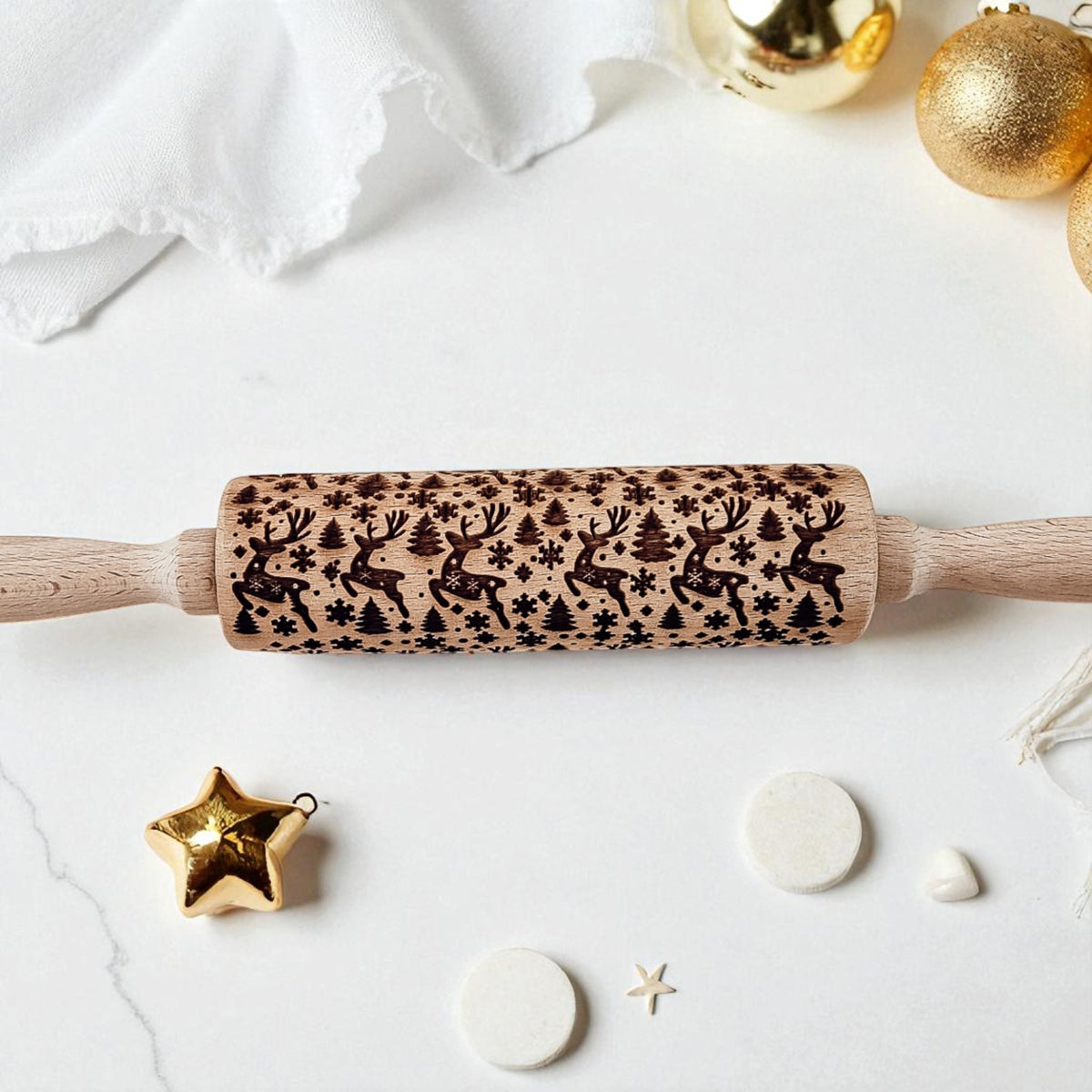 Wooden rolling pin with festive pattern on a white surface with decorative items.