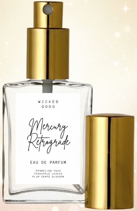 Perfume bottle with gold cap and clear body on a light background