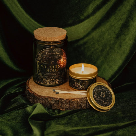 Candle and jar labeled 'Witching Hour' on a wooden stand with green fabric background