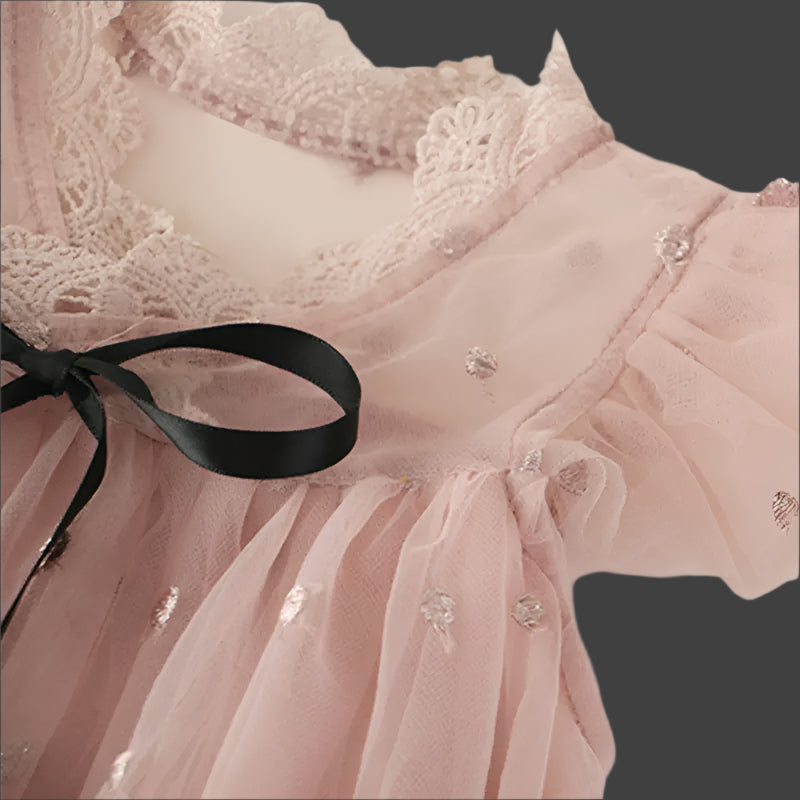Close-up of a pink lace garment with a black ribbon on a light background