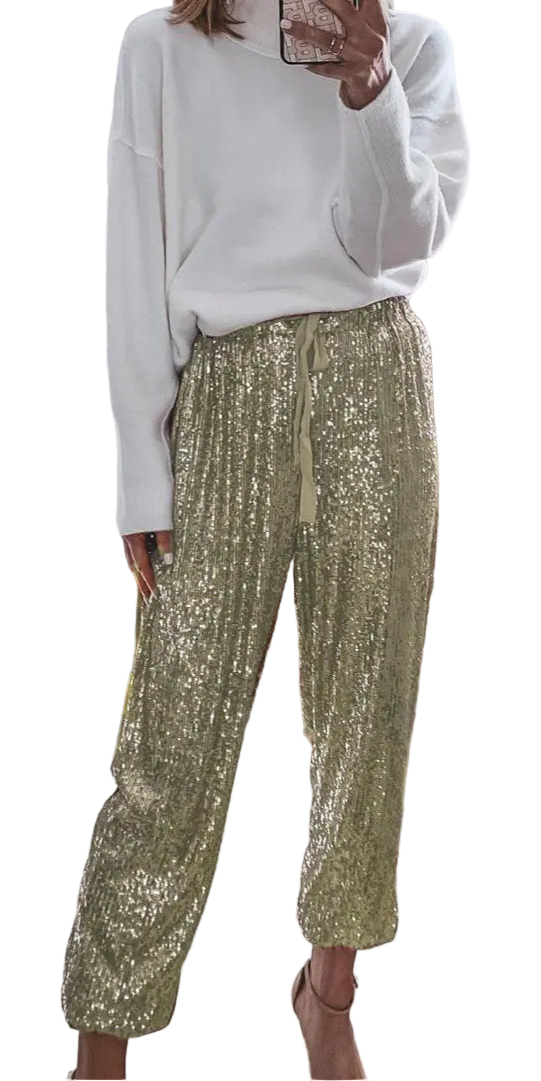 Person wearing a white sweater and gold sequin pants in a home setting.