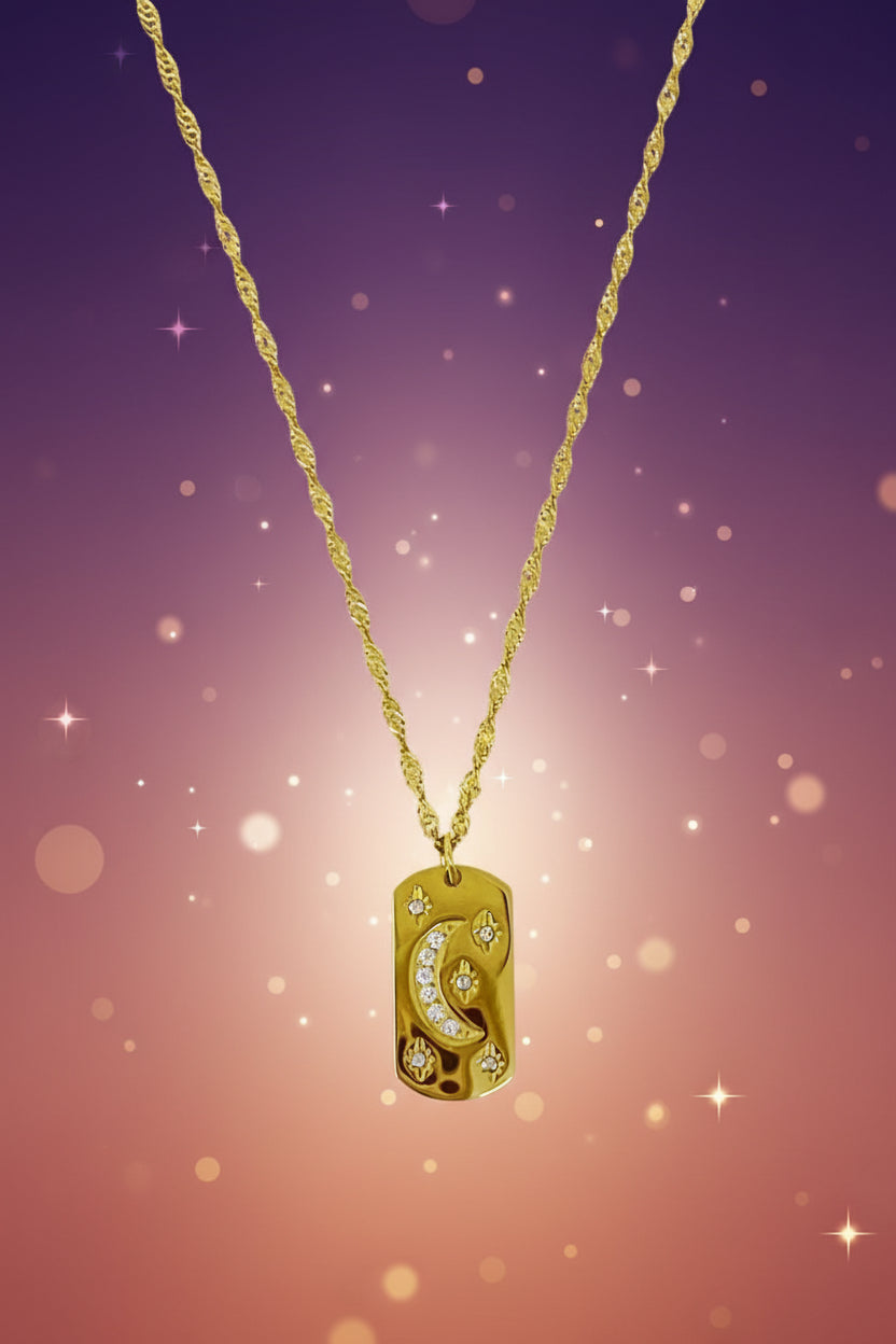 Gold necklace with a dog tag pendant on a marble surface