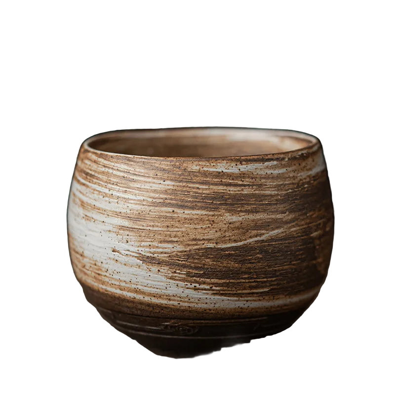 Ceramic cup with brown and beige glaze on a dark background
