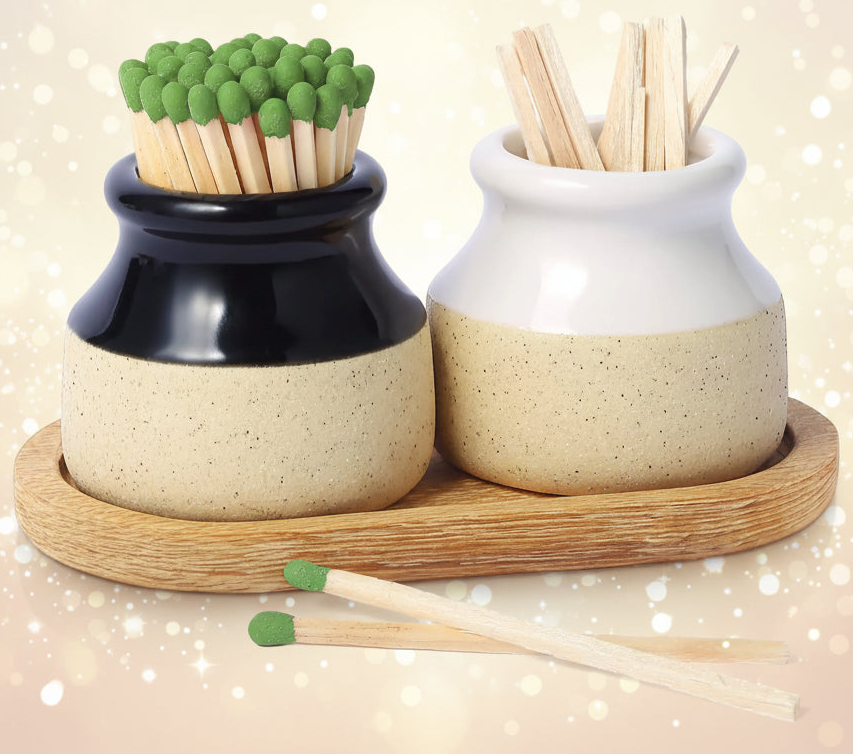 Two ceramic containers with matches and toothpicks on a wooden tray.
